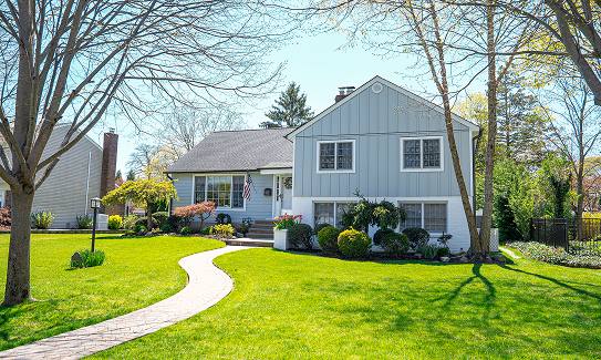 Grey split-level home with board and batten gable