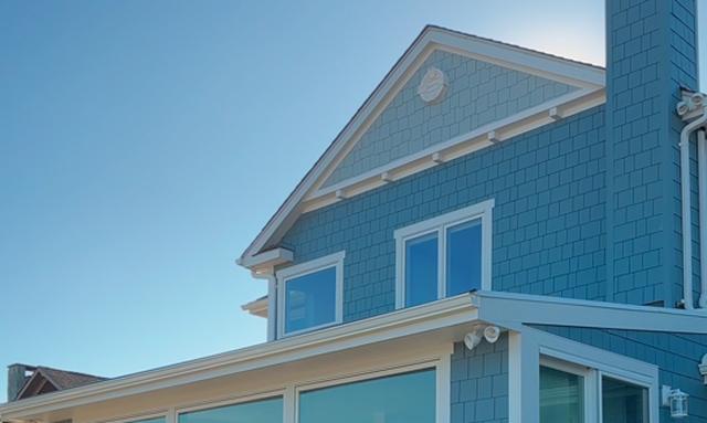 Coastal home with blue James Hardie siding and shingle gable